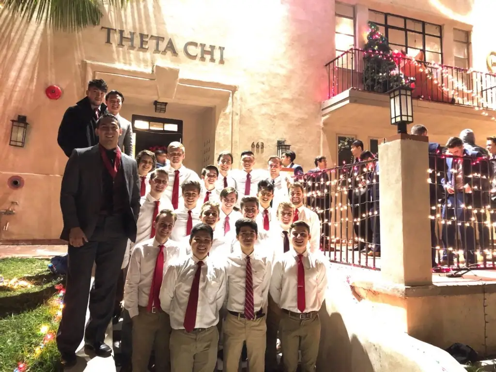 dressed-up group in front of Theta Chi house