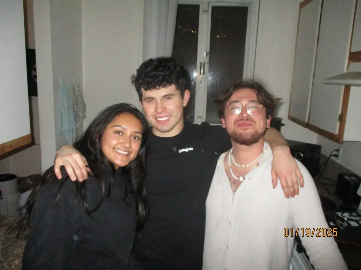 Three friends smiling in the kitchen at the Around the World mixer