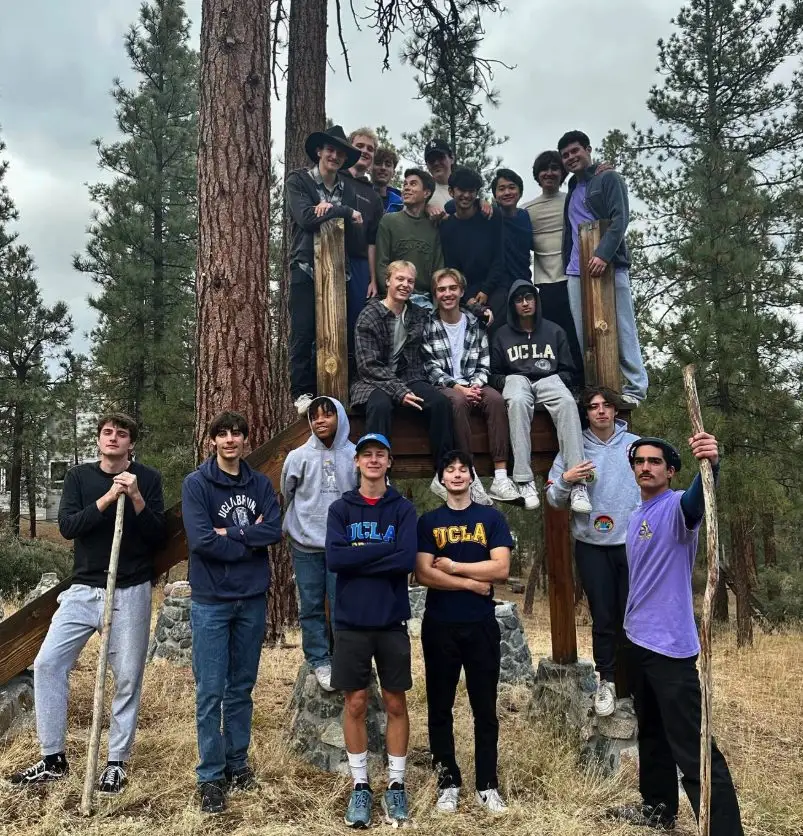 The Fall 2023 pledge class posed on a wooden lookout among pine trees