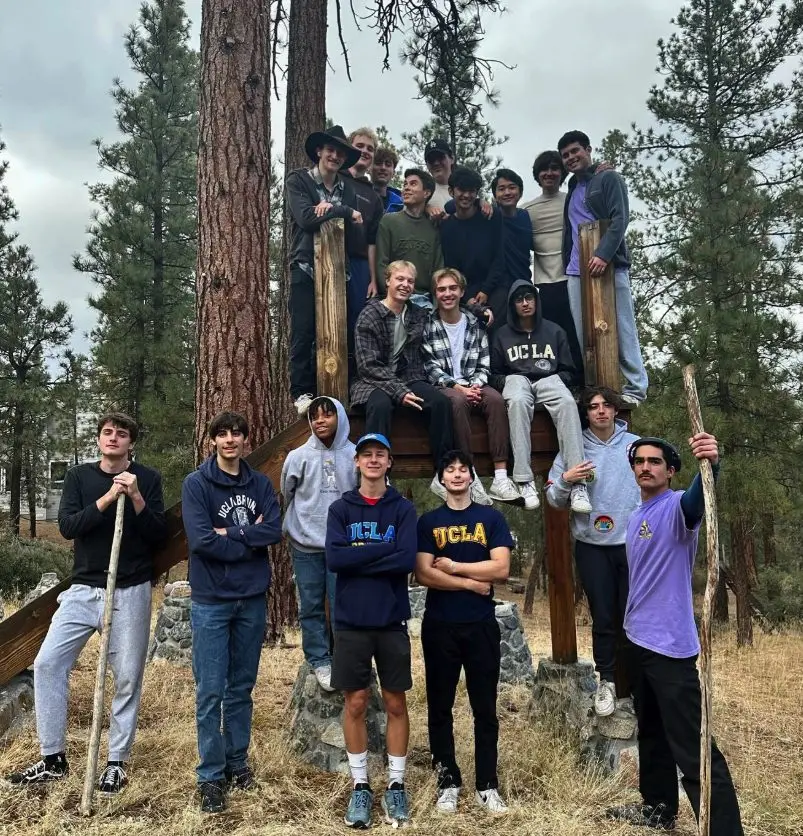 The Fall 2023 pledge class posed on a wooden lookout among pine trees