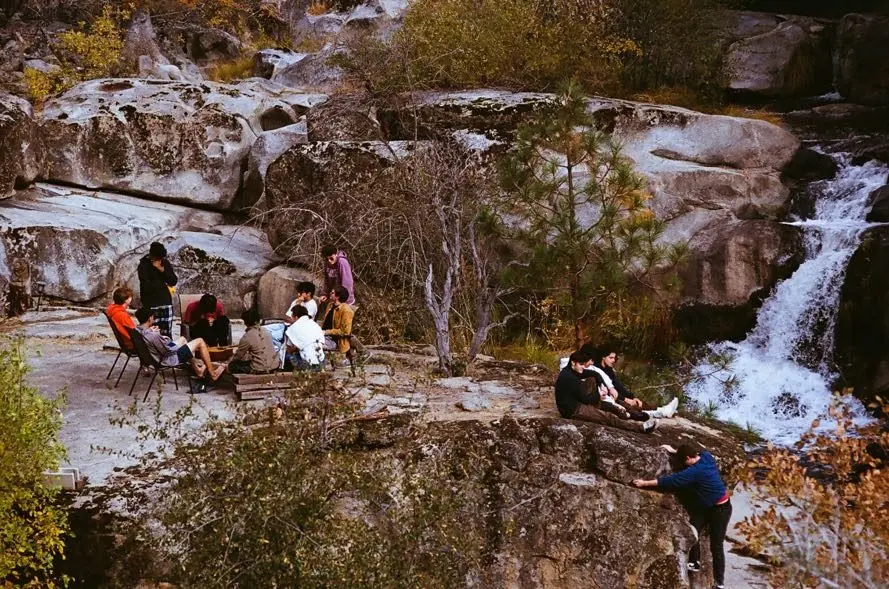 Brothers gathered on granite boulders beside a waterfall on the fall retreat