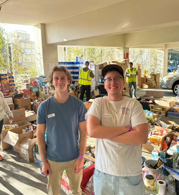 Two brothers at the YMCA donation drive surrounded by boxed supplies