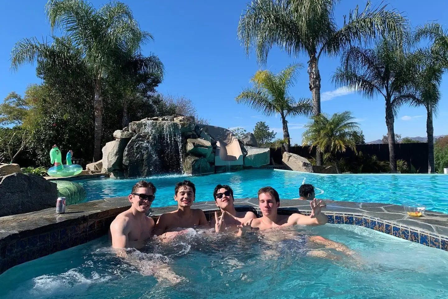 guys swimming by pool waterfall