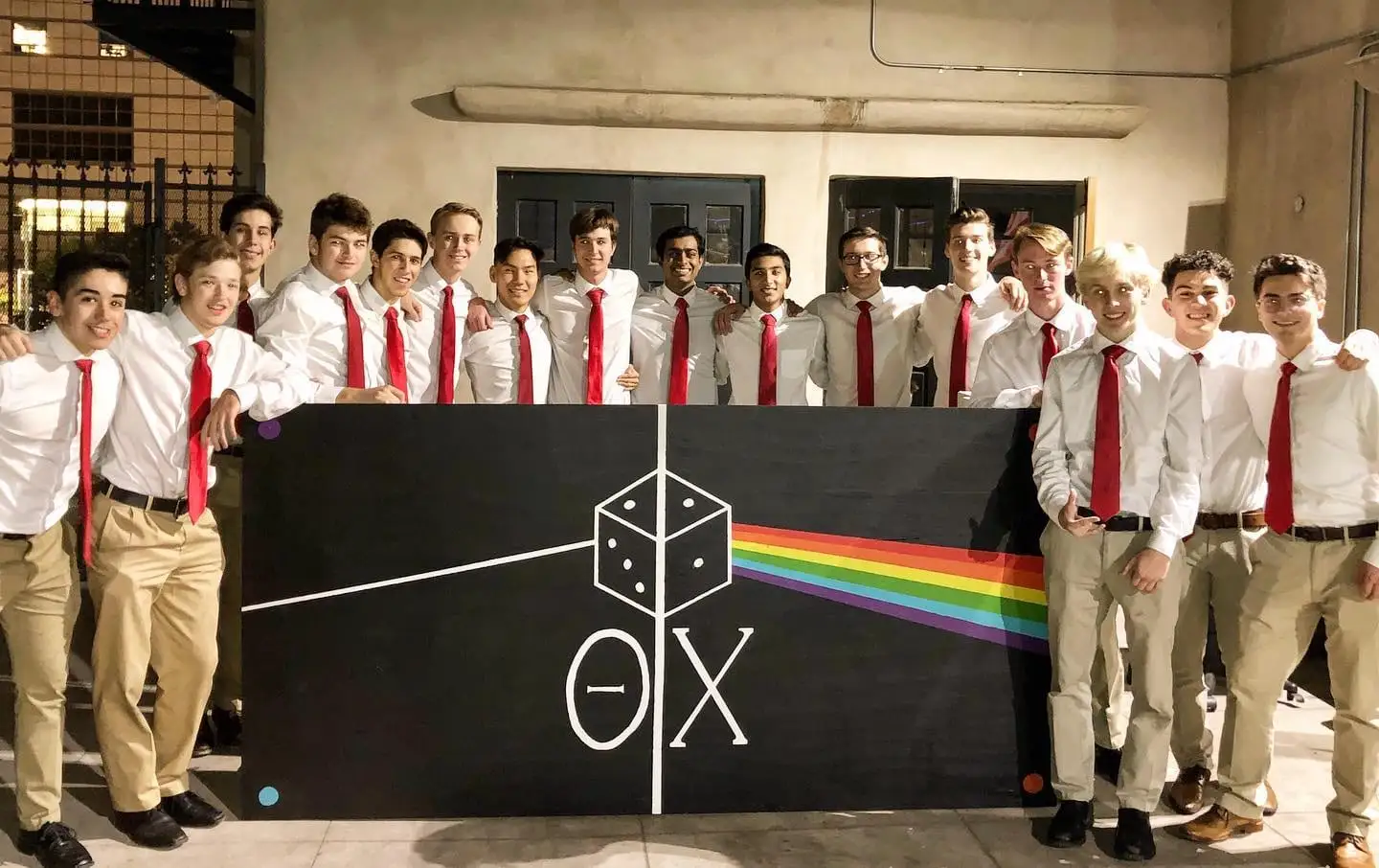 Brothers in red ties in front of the hand-painted Dark Side banner