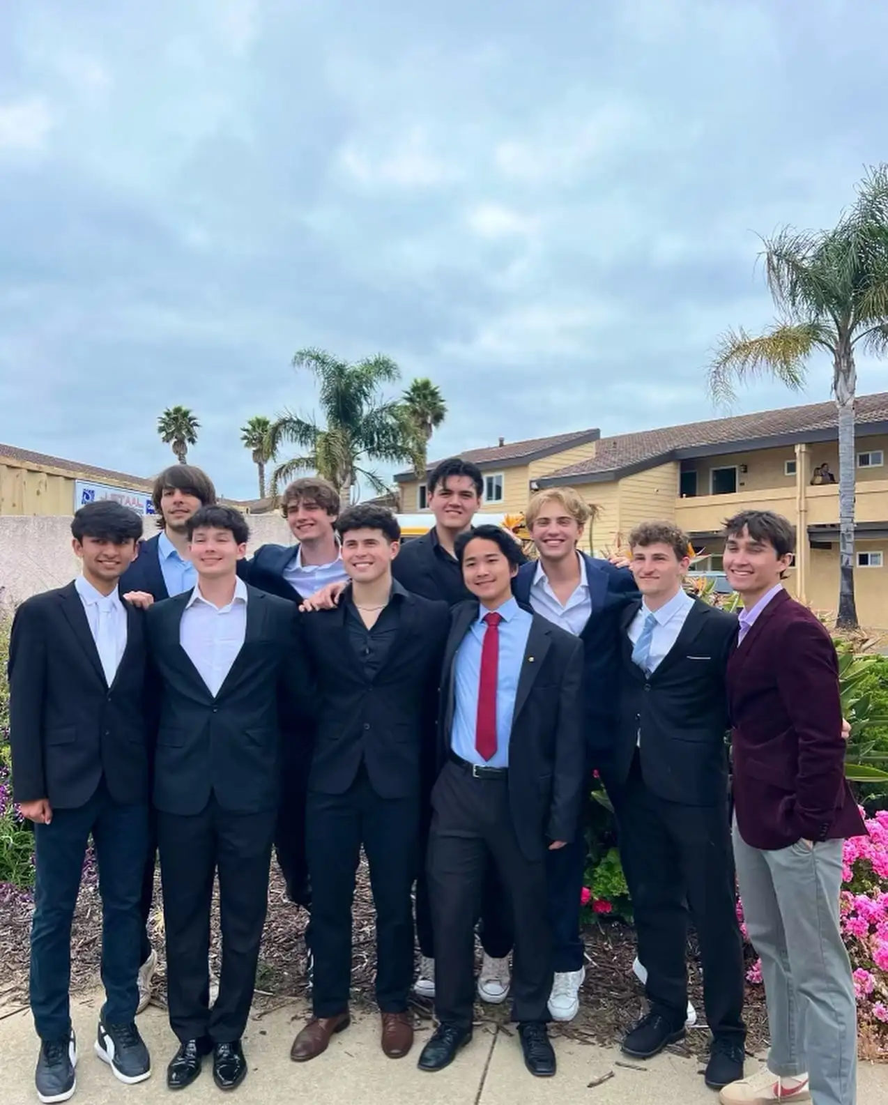 group of brothers in dark suits, greenery