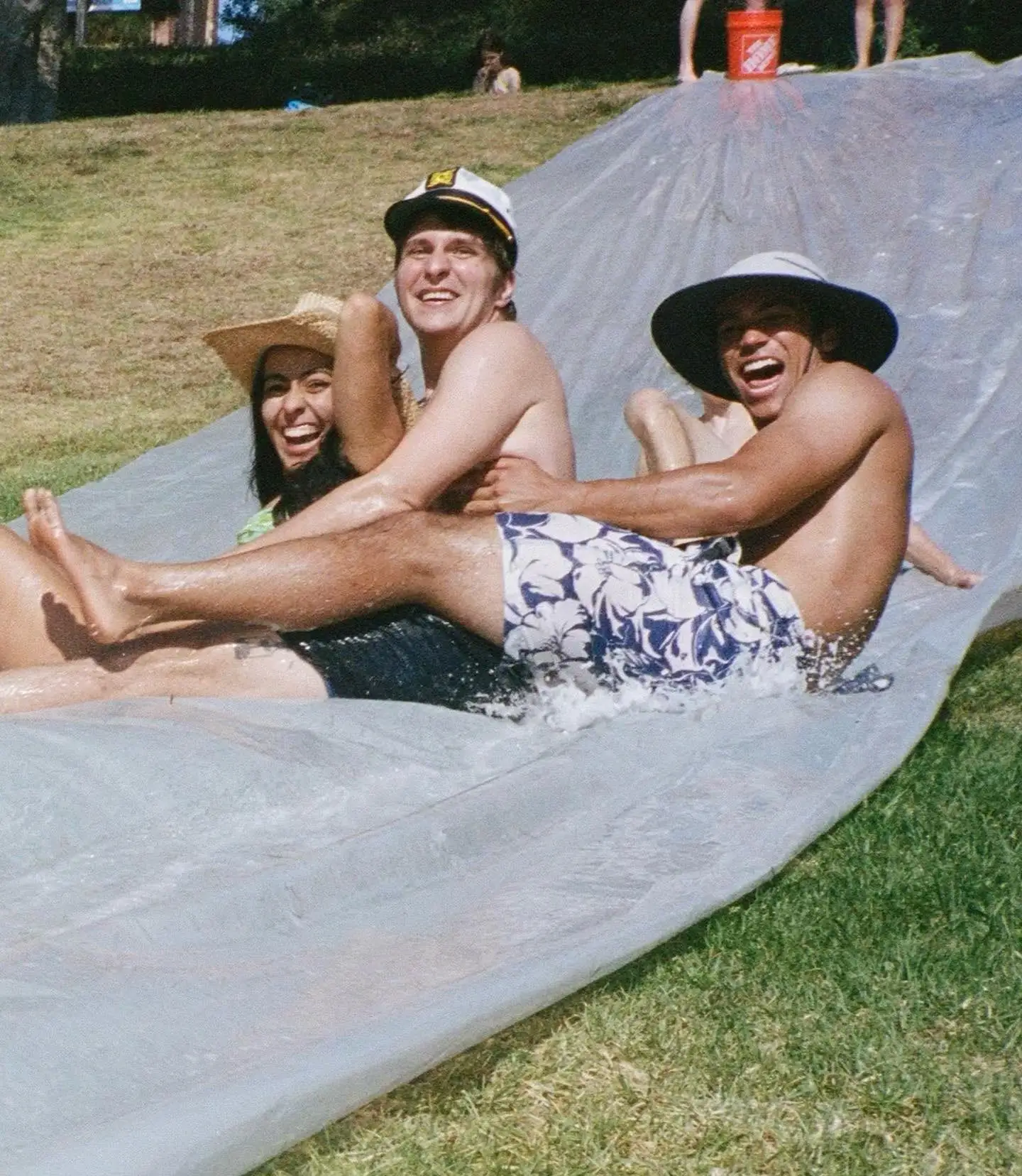 laughing trio riding slip-n-slide